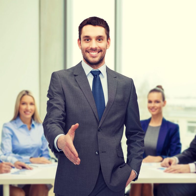 business and office concept - handsome businessman with open hand ready for handshake